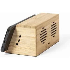 A wooden speaker dock in a triangular shape, featuring a textured surface and slots for sound output.