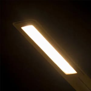 A rectangular ceiling light fixture with a warm white light, set against a dark background.
