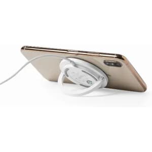 A mobile phone with a white charging cable attached to a circular charging pad on the back. The phone is gold in colour.
