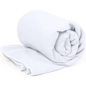 A white rolled towel displayed on a flat surface with a folded section beside it.