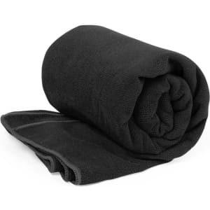 A rolled black towel displayed neatly on a flat surface, featuring a textured fabric.