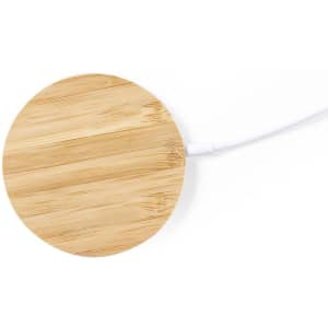A round bamboo wireless charger with a white cable, showcasing a natural wood texture and smooth surface.