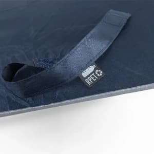 A navy blue reusable bag with a handle, featuring a tag indicating it is made from recycled materials.