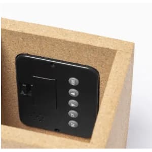 A black device sits inside a light brown box, featuring buttons for various functions.