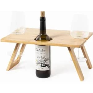 A bamboo table set with a wine bottle in the centre and two wine glasses on each side.