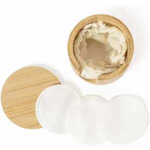 A bamboo container with a lid, featuring reusable cotton pads inside. Three white pads are visible next to the container.