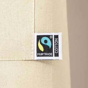 A Fairtrade cotton fabric label featuring a logo on a light beige background.