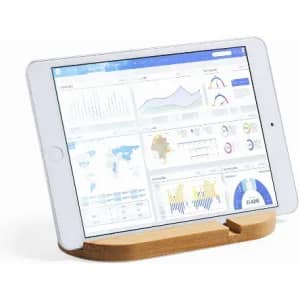 A tablet on a bamboo stand displaying various data charts and graphs. The tablet has a white frame.