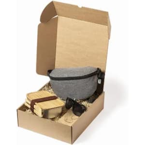 A gift box contains a grey bag, wooden containers, and sunglasses, all nestled in shredded paper.