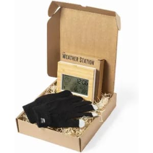 A weather station and black gloves in a cardboard box, with straw filling for presentation.