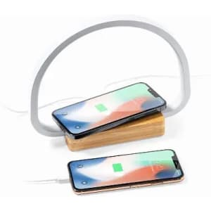A wireless phone charger with a wooden base and a flexible light, featuring two smartphones charging.