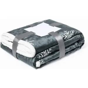 A soft, dark grey blanket with a white fleece lining, featuring a snowflake pattern, neatly folded and secured with a ribbon.