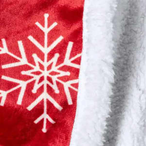 A soft blanket featuring a red side with a white snowflake design and a white, fluffy textured side.