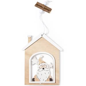 A wooden Christmas decoration featuring a Santa figure inside a house design, with stars and a chimney detail.
