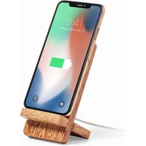 A phone stand made of wood, displaying a phone with a charging symbol. The stand has a minimalist design.