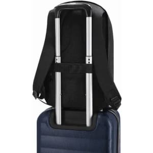A black backpack with adjustable straps and a trolley handle pass-through feature. The base is resting on a blue suitcase.