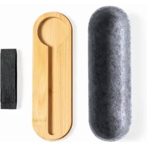 A bamboo spoon and a grey container, accompanied by a black strap, all displayed together.