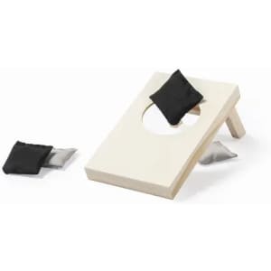 A cornhole game set with a cream board and black and grey bean bags. The board features a circular hole.