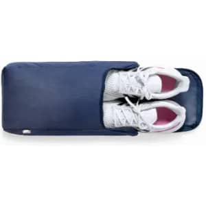 A navy storage bag containing a pair of white sports shoes, featuring a zip closure and a simple design.