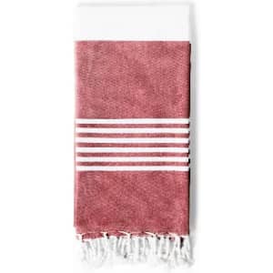 A terracotta-coloured towel with white stripes and fringed edges, neatly folded. It features a simple design.