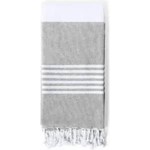A grey and white towel features a patterned stripe design and fringed edges. It has a logo on one side.