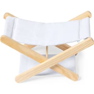 A folding chair with a wooden frame and white fabric seat and backrest. It features an X-shaped design.