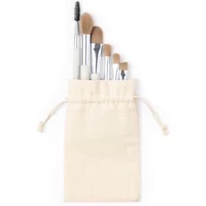 A set of makeup brushes in a cream-coloured drawstring pouch, featuring various brush sizes and shapes.