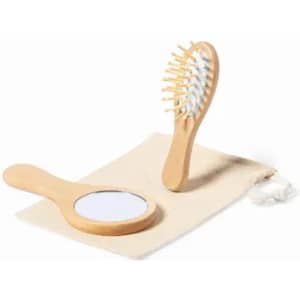 A wooden hairbrush and mirror set displayed on a fabric pouch. The handle and bristles are made of wood.