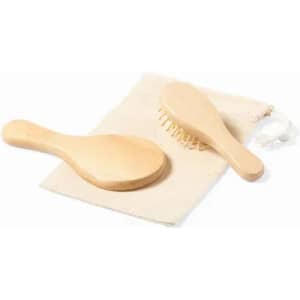 A wooden hairbrush and comb set displayed on a fabric pouch. The products are light-coloured with a natural finish.