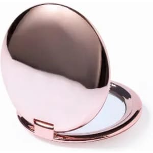 A compact mirror with a shiny rose gold exterior, featuring a smooth surface and a reflective interior.