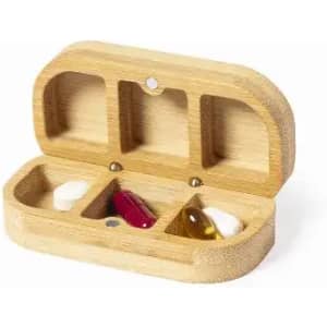 A wooden pill organiser with three compartments, containing two capsules and one tablet. It has a natural finish.