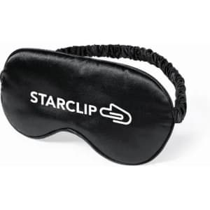 A black sleep mask featuring a logo, designed for comfort with an elastic band for a secure fit.