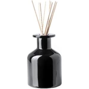 A black ceramic diffuser bottle with wooden reeds protruding from the top. It has a glossy finish and a simple design.
