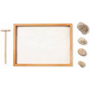A wooden framed sand tray with a small rake and four decorative stones in various colours.