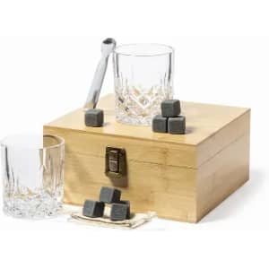 A wooden box containing whiskey stones, with two crystal glasses and a metal spoon on display.