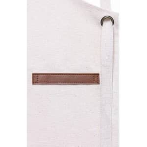 A white tote bag with a brown leather patch and a white strap. The bag features a simple design.