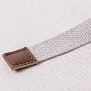 A textured strap in light cream colour, featuring a brown leather accent at one end.