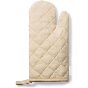 A cream-coloured oven mitt with a quilted pattern and a hanging loop for storage.