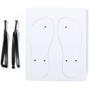 A pair of black sandal straps alongside a white template with outlines of foot shapes and holes for straps.