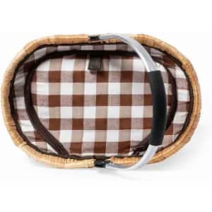 A picnic basket with a checkered brown and white interior and a sturdy handle, featuring a natural woven exterior.