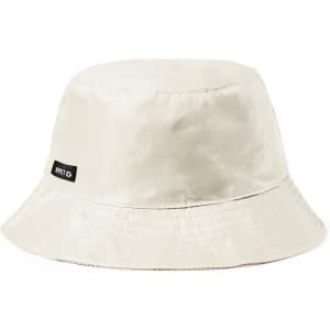 A bucket hat in a light beige colour with a black logo patch. The fabric has a smooth, shiny finish.