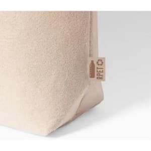 A drink bottle with a textured beige finish and a small eco-friendly tag.