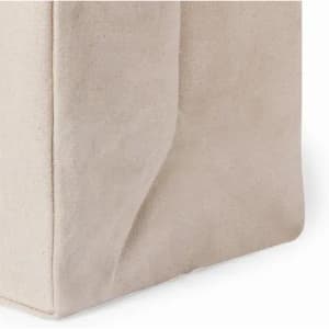 A product featuring a soft, beige fabric texture with a structured shape and subtle folds. It has a branding logo.