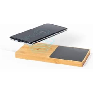 A wireless phone charger with a bamboo base and a black charging pad, featuring a smartphone aligned above it.