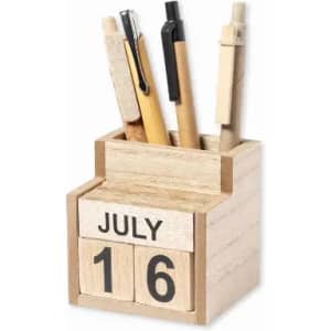A wooden desk organiser holding various pens, with a calendar block displaying the date and month.