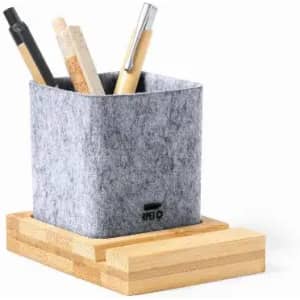 A grey felt pencil holder with various pens and pencils, placed on a wooden base.