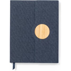 A notebook with a dark blue fabric cover and a circular bamboo accent, featuring a ribbon bookmark.