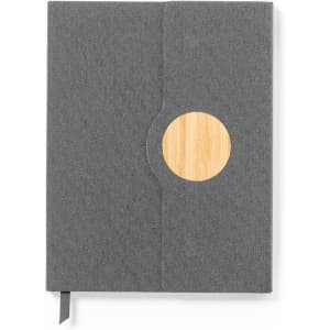 A grey notebook with a wooden circular accent and a ribbon bookmark, featuring a textured fabric cover.