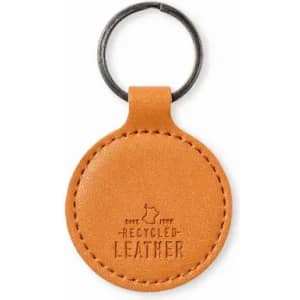 A keychain made of recycled orange leather with a circular design and a metal ring.