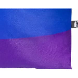 A cushion with a textured surface featuring a gradient from blue to purple, with a small tag on one side.
